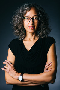 Author photo of Sofia Samatar, wearing a black shirt and standing with her arms crossed