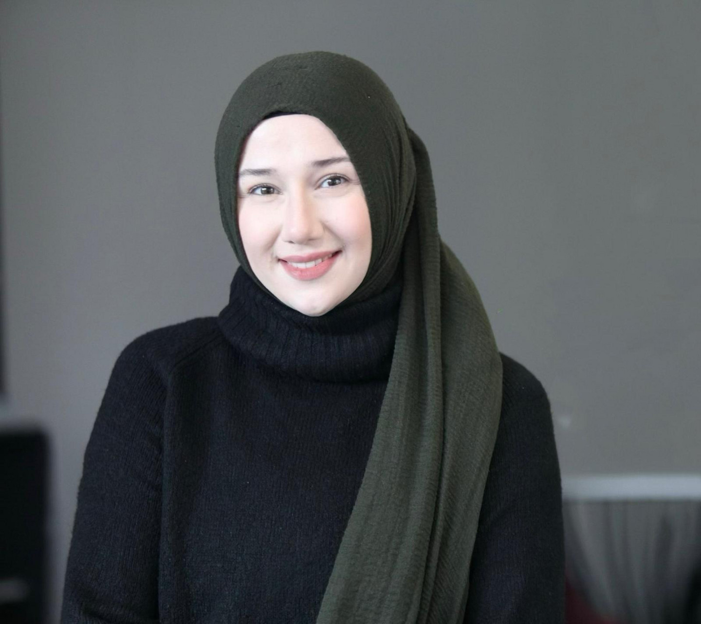Portrait of Rumeysa Ceylan smiling; she is wearing a black pullover and grey hijab